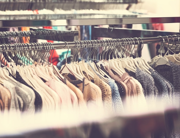 Finished clothing pieces hanging on a rack, ready for delivery to emerging fashion brands.