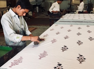Artisan applying vibrant hand block prints on fabric in a Jaipur workshop.