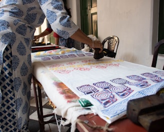 A skilled artisan hand-block printing a fabric with traditional Jaipur patterns.